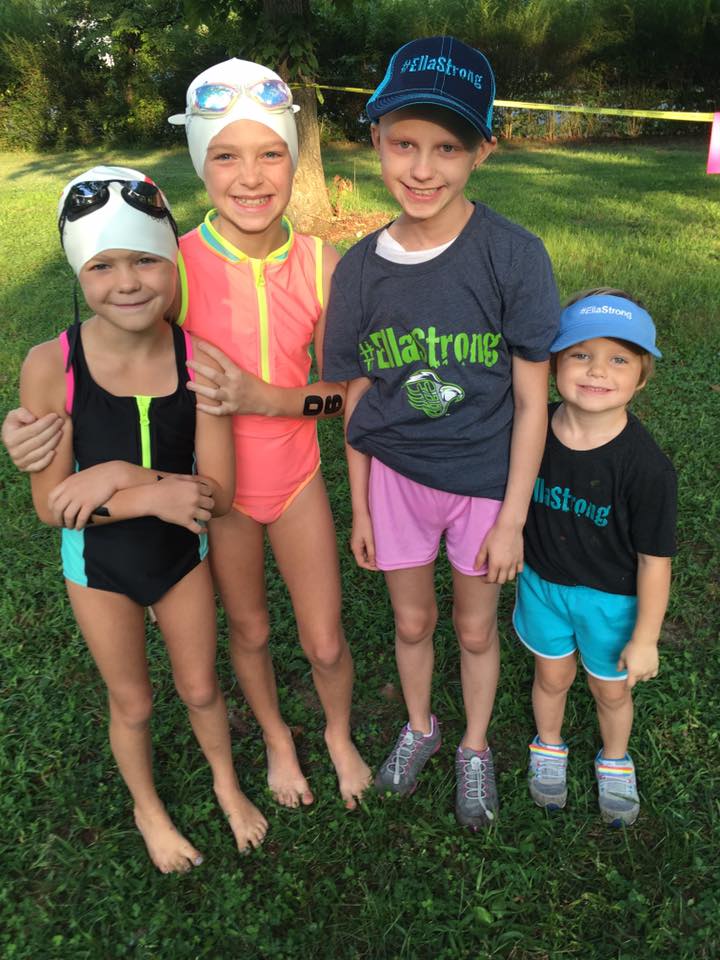 Ella and three other children in #EllaStrong shirts and swim caps before a youth triathlon
