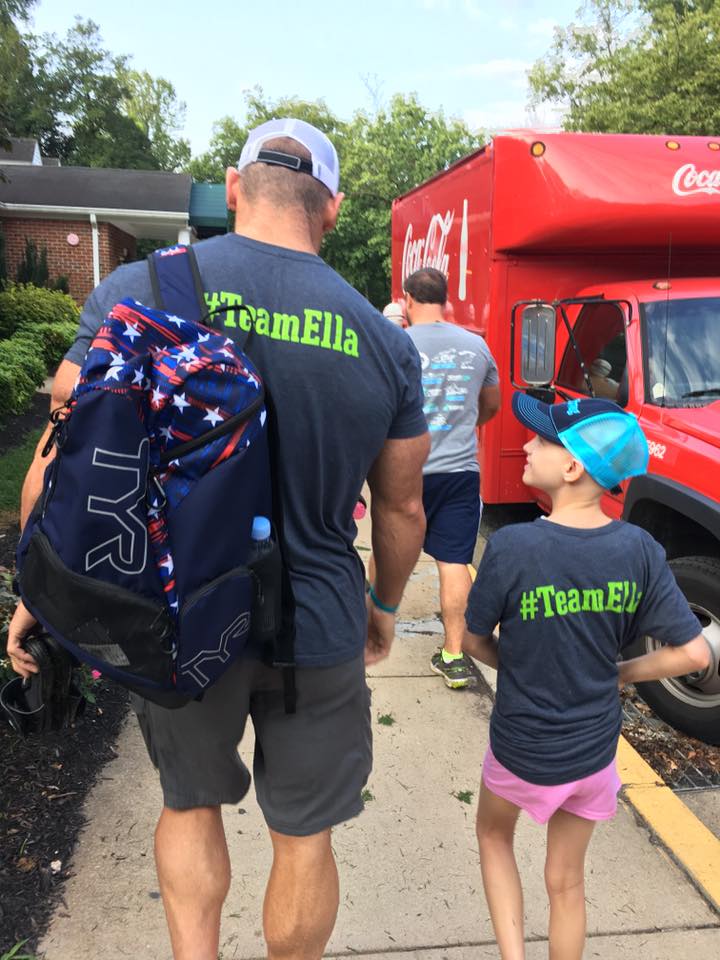 Ella walking with her dad, both wearing #TeamElla shirts on race morning